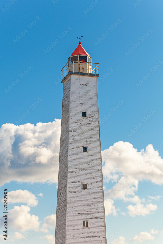 Tall gray lighthouse tower with red light and top