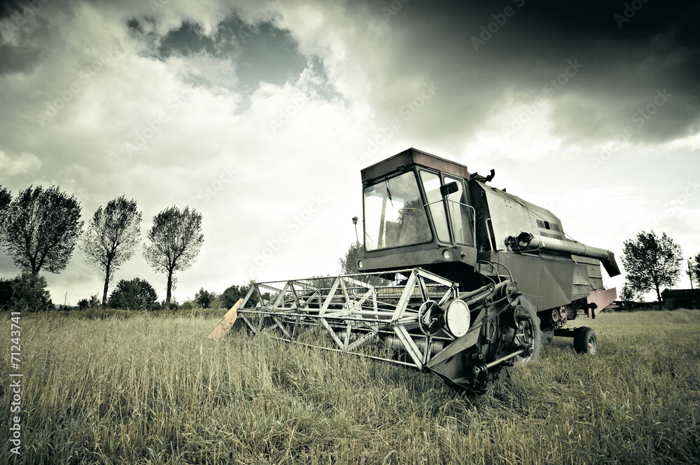 Naklejka premium Old broken combine abandoned in the field during work