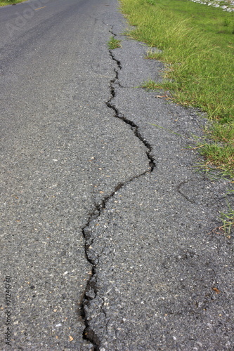 road asphalt damage crack grass green growing