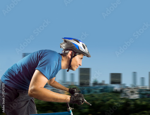 sporty man cycling at city photo