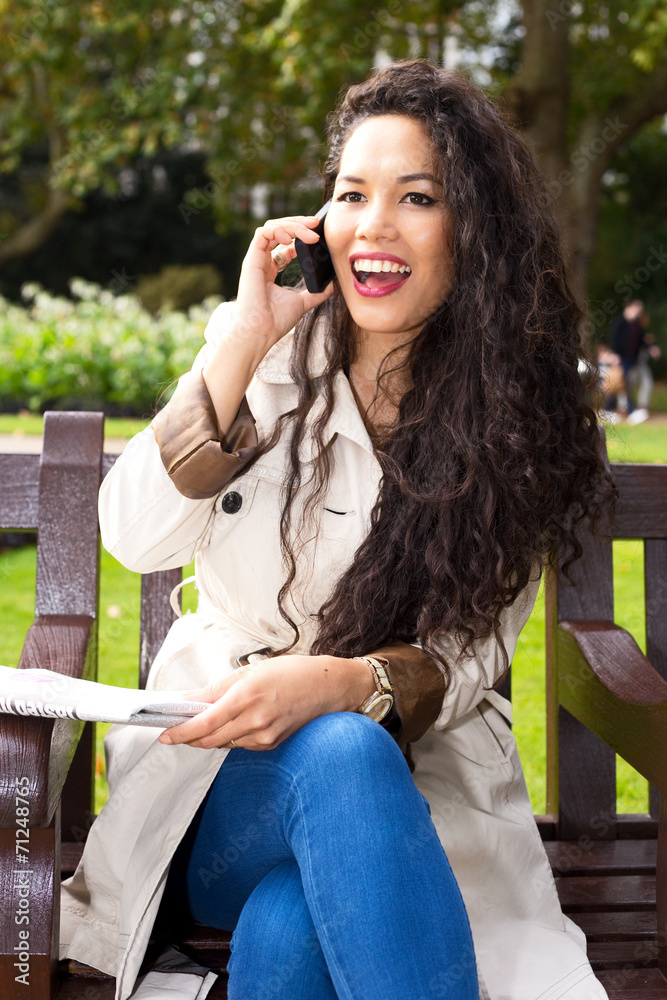 young woman talking on the phone with newspaper. young woman talking on the phone with newspaper.