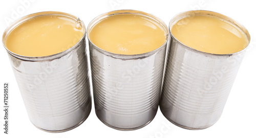 Condensed milk in tin can over white background 