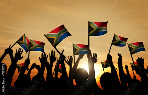 Obraz na płótnie Group of People Waving South African Flags in Back Lit