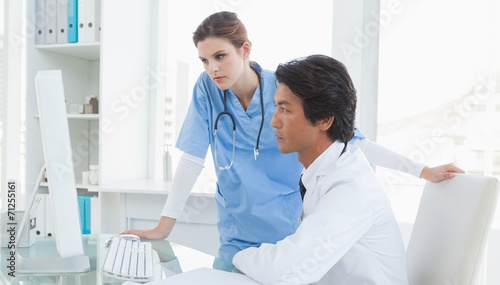 Doctor and surgeon looking at a computer