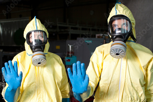 Zwei Helfer in Schutzanzügen warnen vor Ebola photo