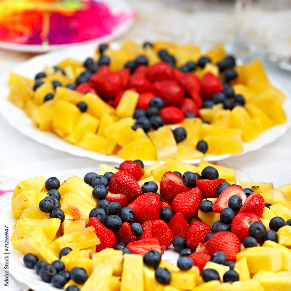 Fruits and berries on a plate on the festive table. Fruits and berries on a plate on the festive table.