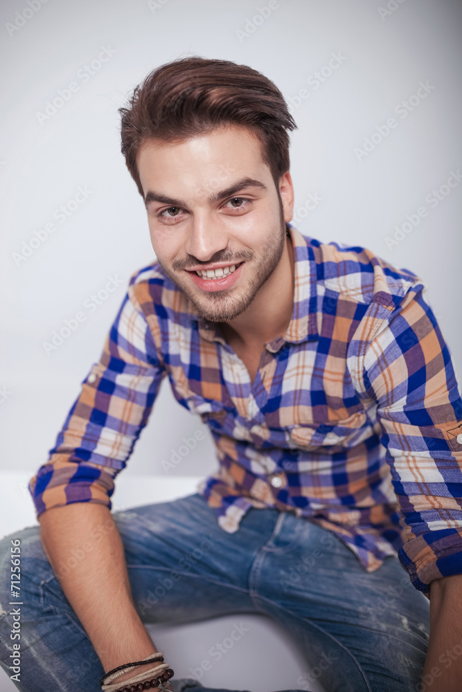 fashion man smiling while relaxing on the floor. fashion man smiling while relaxing on the floor.