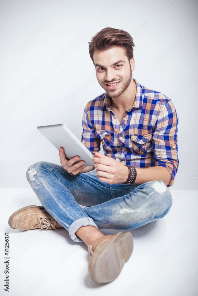 Happy young man holding a tablet pad computer Happy young man holding a tablet pad computer