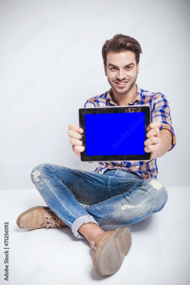 fashion man sitting while showing you the computer screen fashion man sitting while showing you the computer screen
