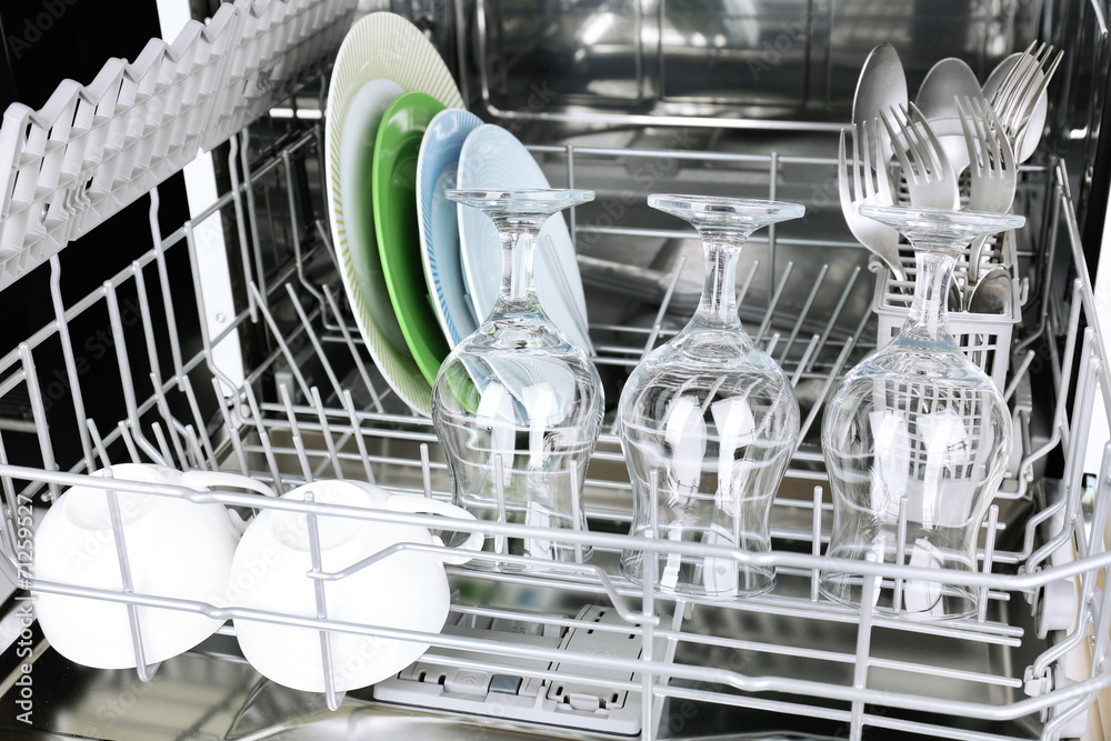 Open dishwasher with clean utensils in it Open dishwasher with clean utensils in it