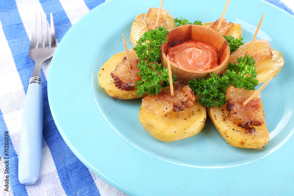 Baked potato with bacon on plate, on wooden background