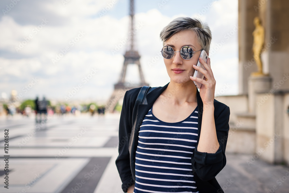 Young woman talking with mobile phone in front of the Eiffel Tow