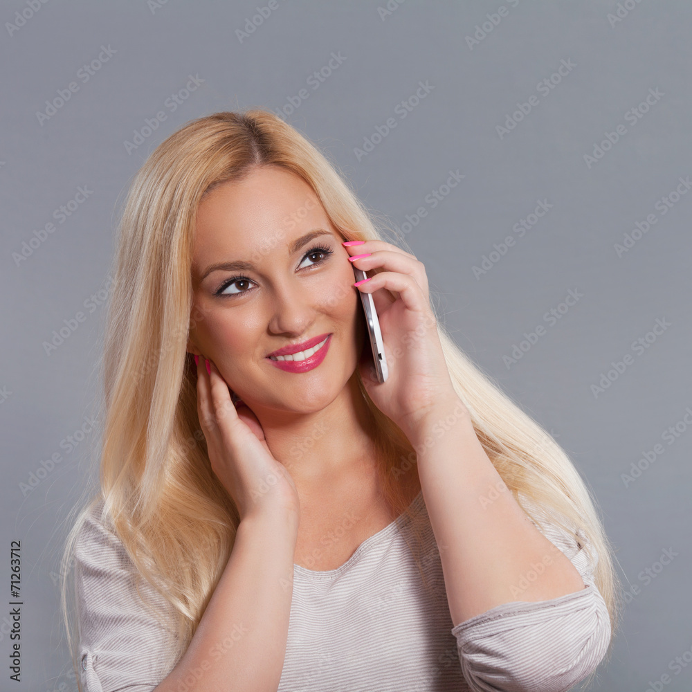 Pretty young woman talking on mobile phone. Studio shot. Pretty young woman talking on mobile phone. Studio shot.