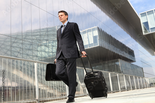businessman walking with trolley and bag, business travel photo