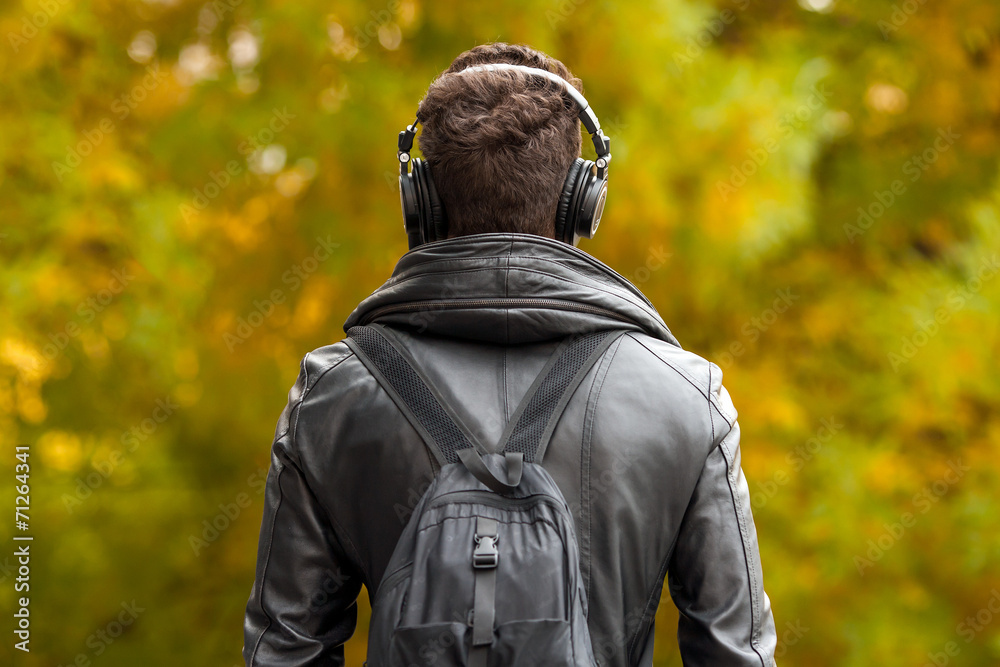man in headphones on the street. admiring the autumn nature
