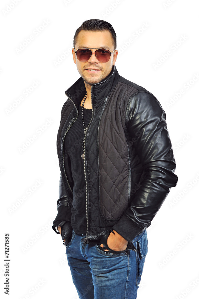 Fashion portrait of young man in jeans and black jacket posing o Fashion portrait of young man in jeans and black jacket posing o