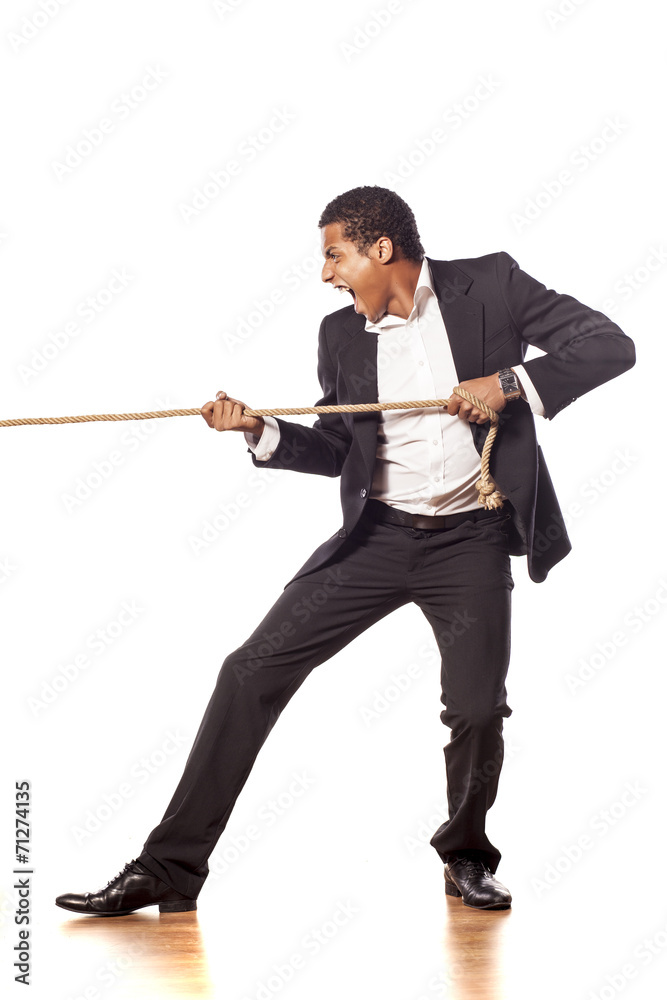 African businessman pulling a rope on white background African businessman pulling a rope on white background