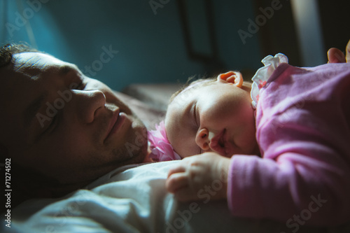 Image of young dad with cute little daughter in his arms