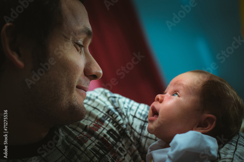 Image of young dad with cute little daughter in his arms