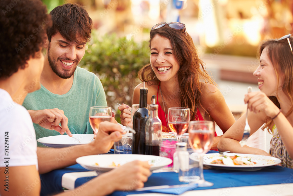 Group Of Young Friends Enjoying Meal In Outdoor Restaurant Group Of Young Friends Enjoying Meal In Outdoor Restaurant