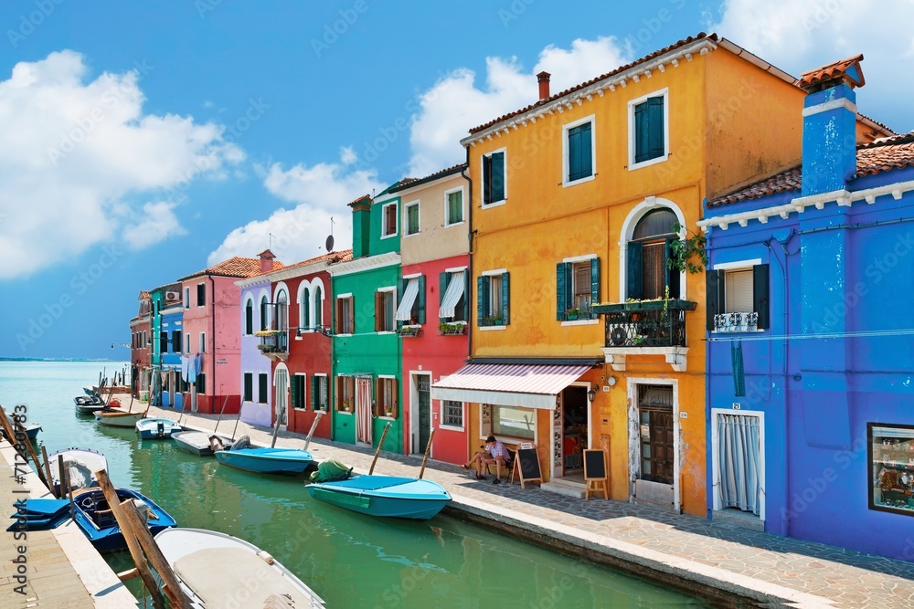 colorful houses by the water canal at the island Burano