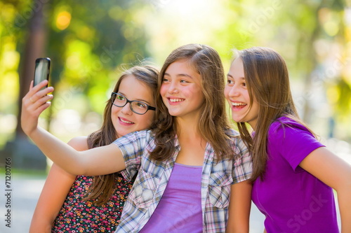 Teenage girls taking selfie in park