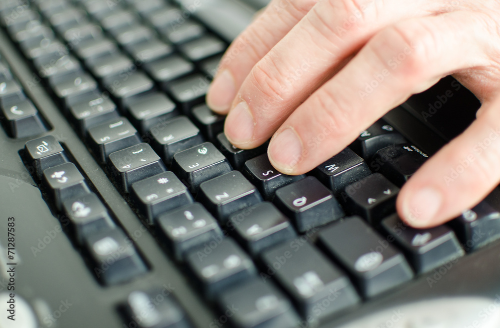 Hand typing on a computer keyboard Hand typing on a computer keyboard