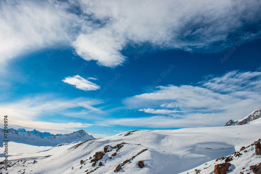 Obraz premium Snowy blue mountains in clouds
