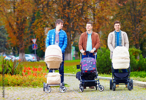 Schilderij op canvas fathers walking with buggies in city park, parental leave