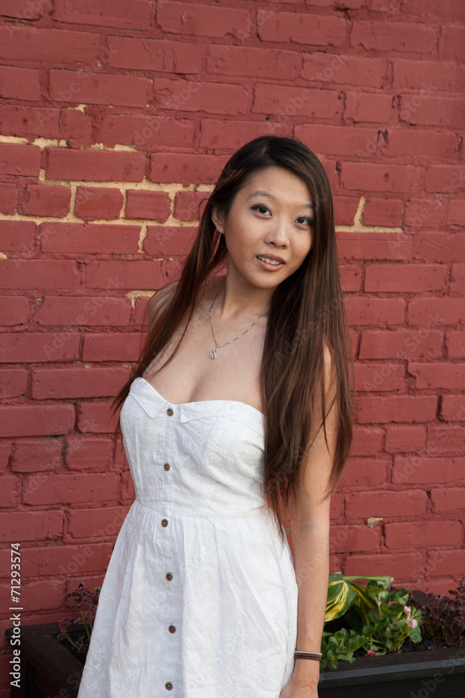 Asian woman besdie a red brick wall Asian woman besdie a red brick wall