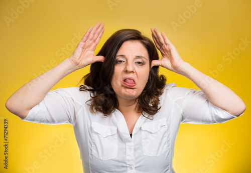  bully woman sticking tongue out isolated on yellow background  photo