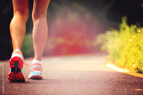young fitness woman legs runner running on trail