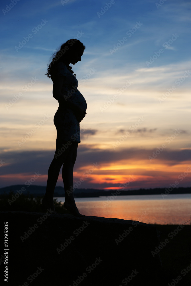 Silhouette of woman touching the belly