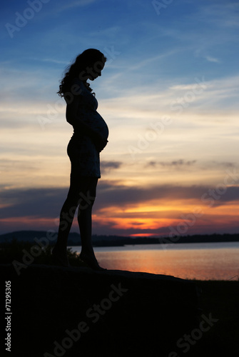 Silhouette of woman touching the belly