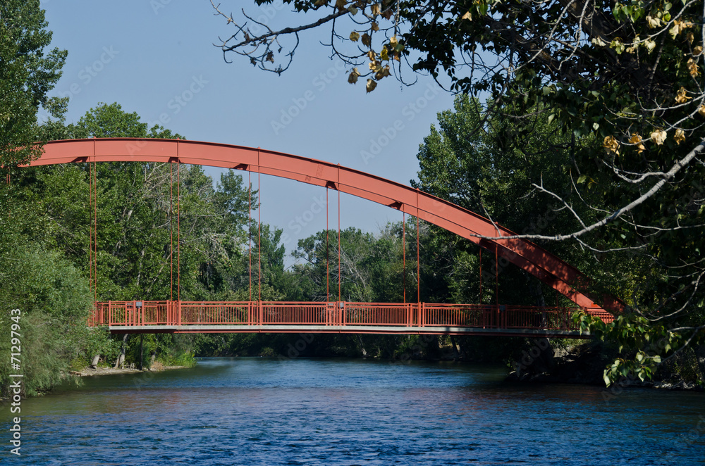 Red Bridge Extending Over the River - obrazy, fototapety, plakaty 