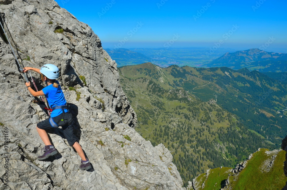 Kind beim Klettern und Sichern am Klettersteig