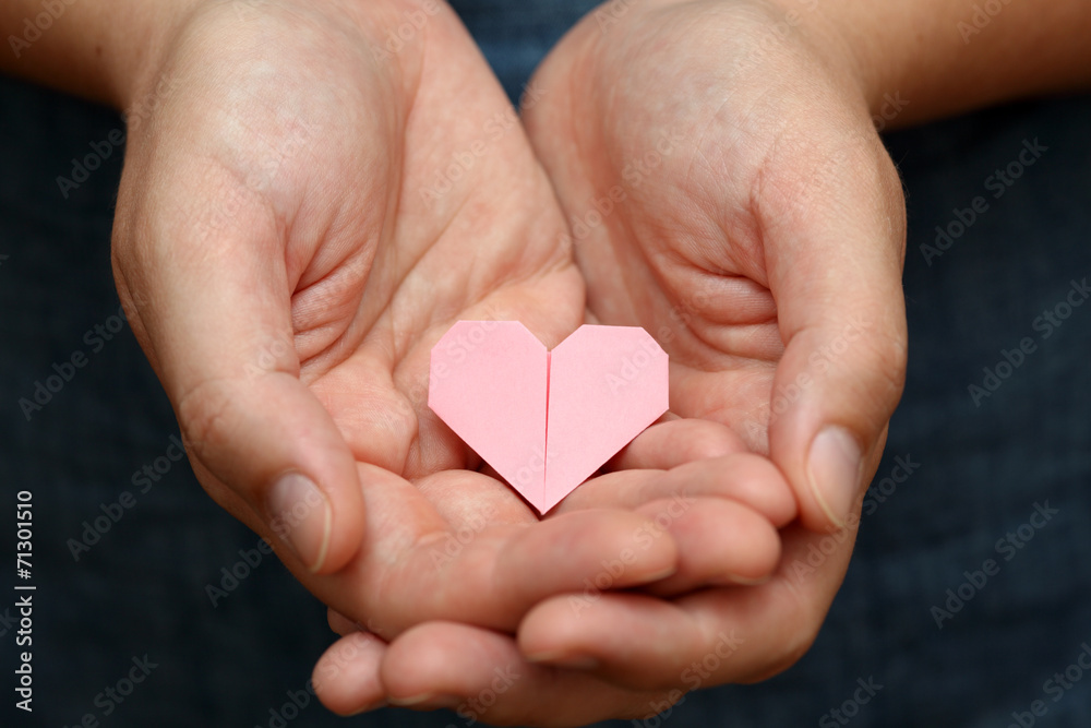 Obraz premium Origami heart in human hands.