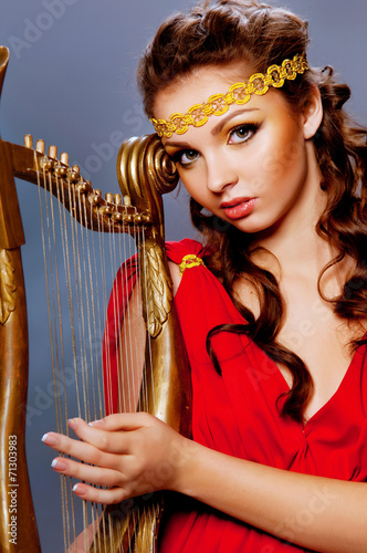 Canvastavla beautiful young girl playing the harp