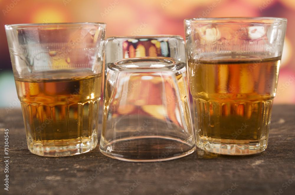 glass of rum whiskey over defocused lights background glass of rum whiskey over defocused lights background