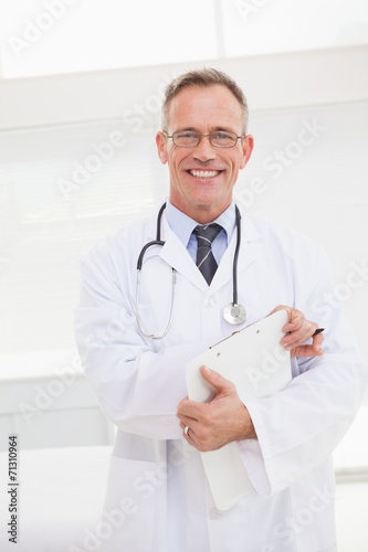 Smiling doctor holding a clipboard