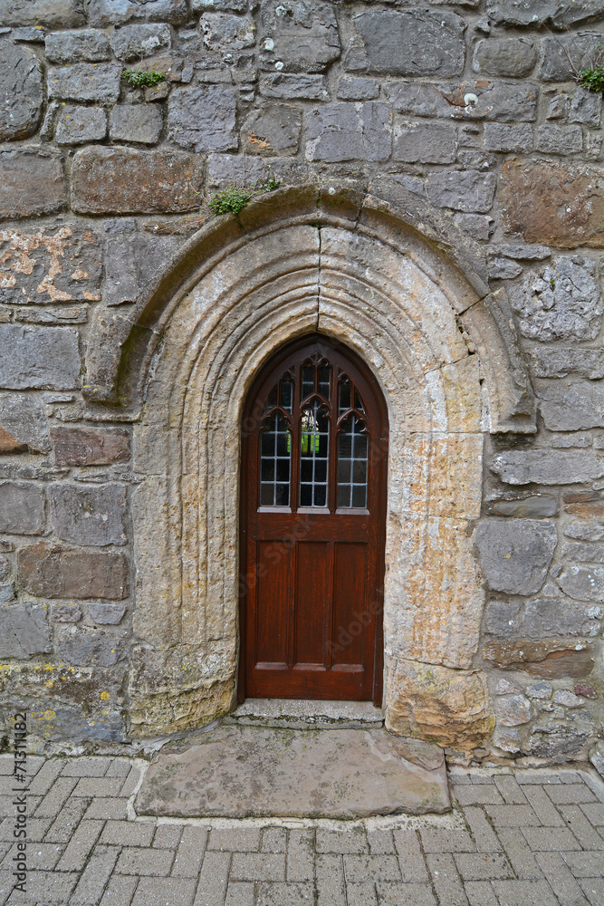 A small wooden door, in a stone church wall