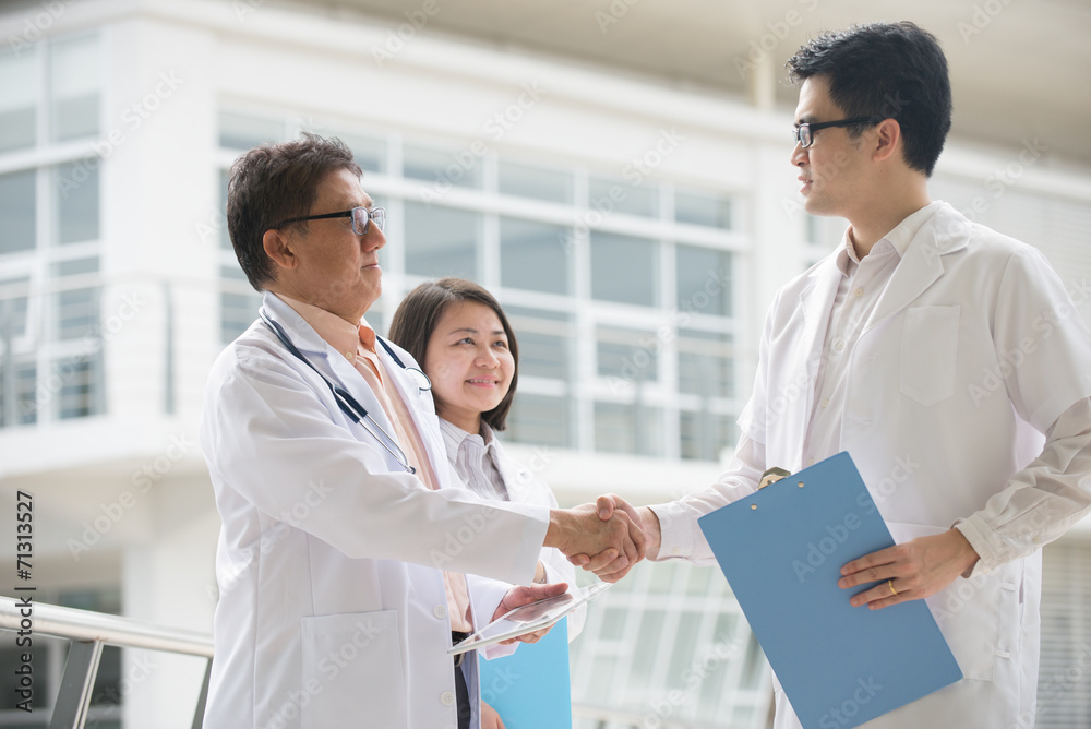 Asian medical team of doctors shaking hands inside hospital buil Asian medical team of doctors shaking hands inside hospital buil
