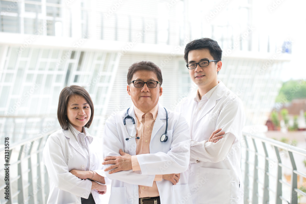 Asian medical team standing inside hospital building Asian medical team standing inside hospital building
