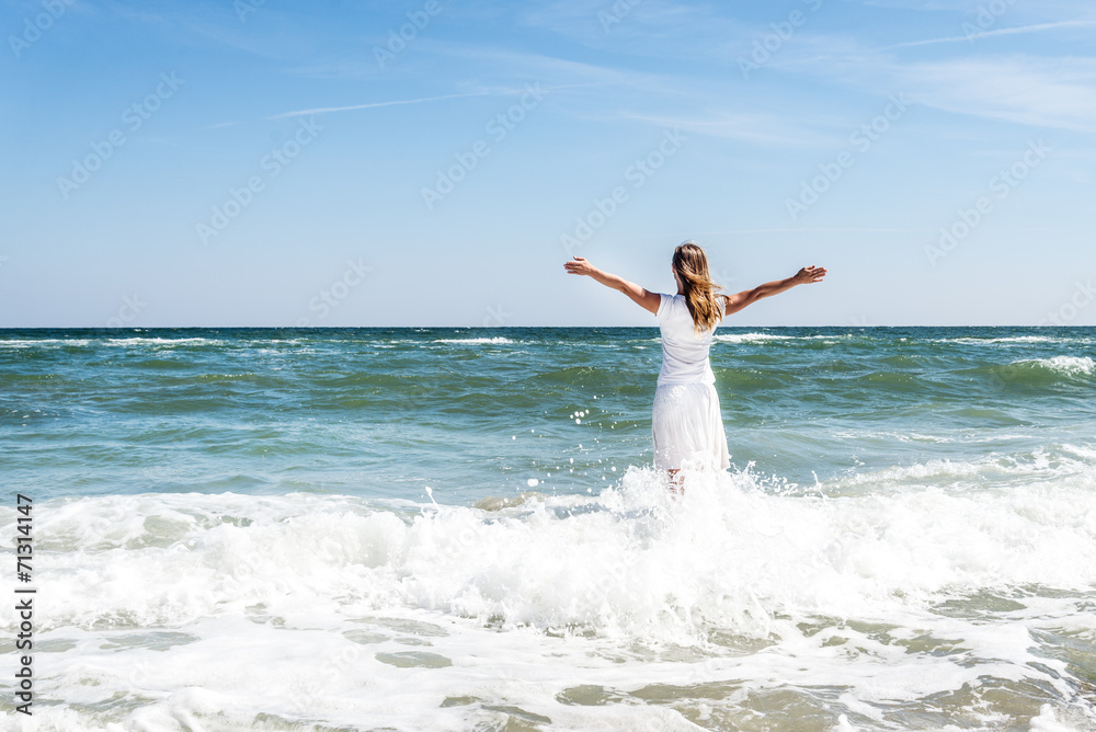Woman in summer dress standing on a sea Woman in summer dress standing on a sea