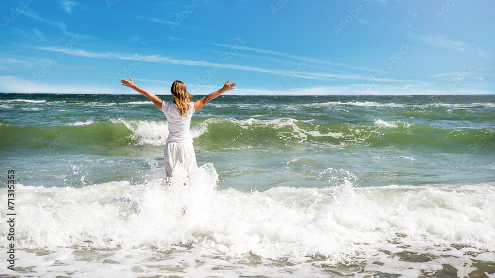 Woman in summer dress standing on a sea Woman in summer dress standing on a sea