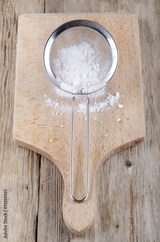 powdered sugar in a stainless steel colander powdered sugar in a stainless steel colander