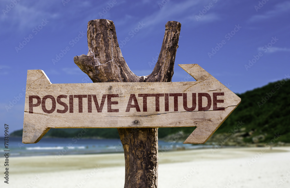 Positive Attitude wooden sign with a beach on background