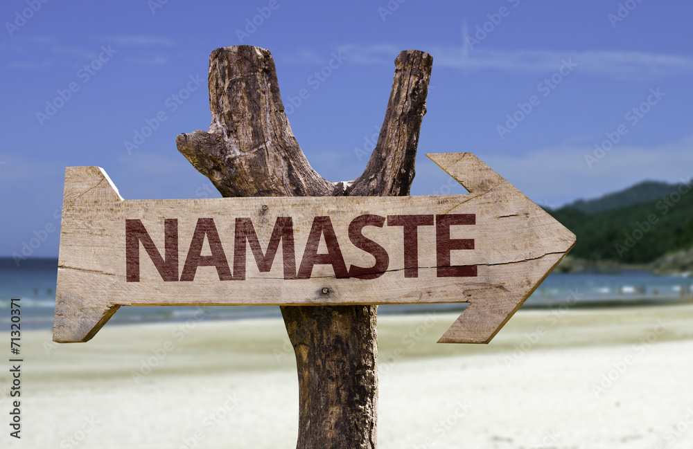 Namaste wooden sign with a beach on background