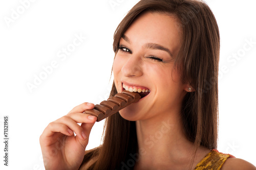 Beautiful young caucasian woman eating chocolate