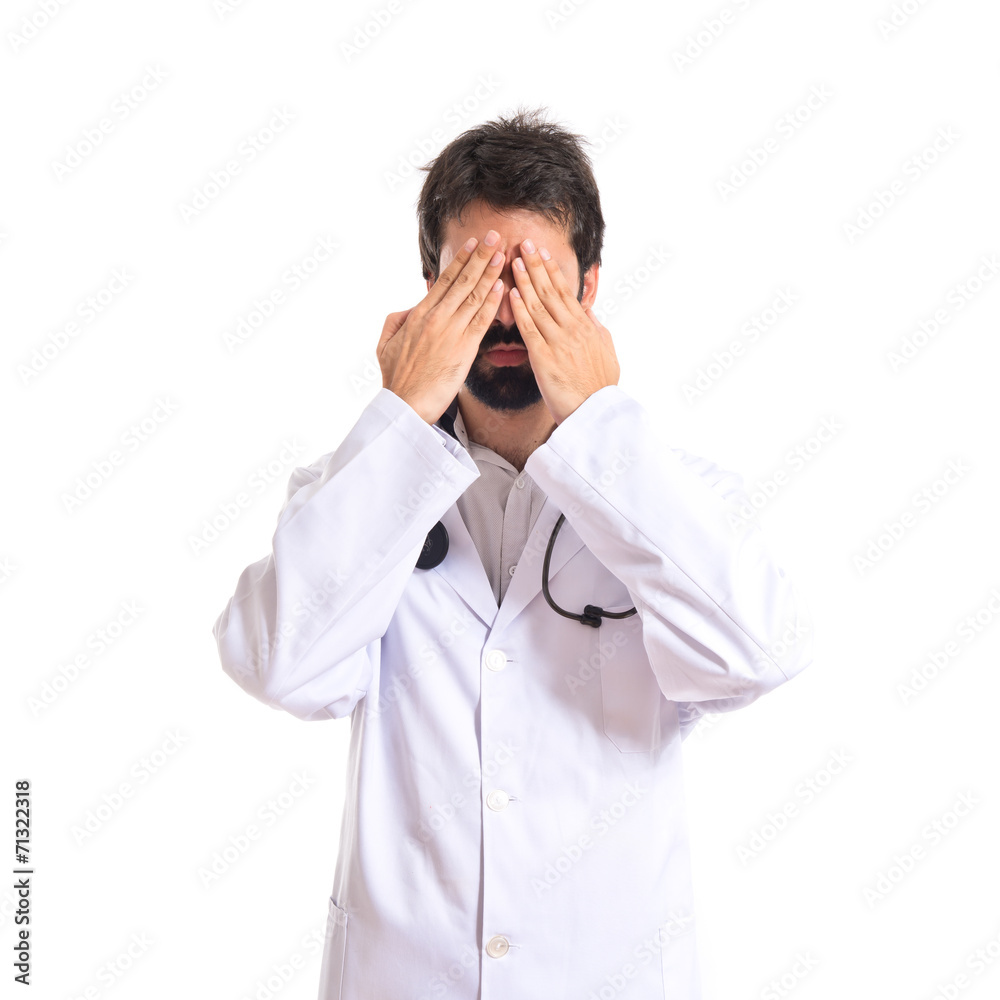 Doctor covering his eyes over isolated white background Doctor covering his eyes over isolated white background